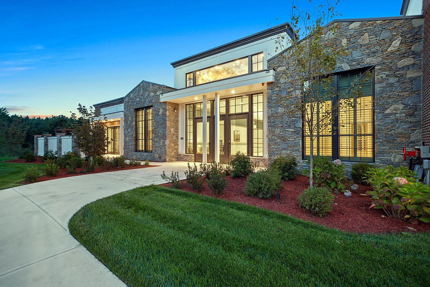 Exterior view of Bedford Event Center in Bedford, NH, showcasing stone facade, modern windows, and landscaped entrance for weddings and events