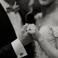Black-and-White Photo of Couple Holding Hands at Wedding